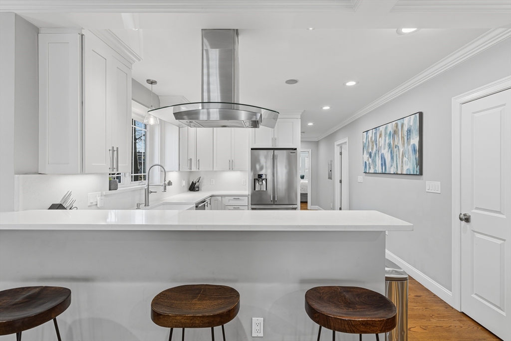 491 Washington Street, Unit 1 Braintree, MA 02184 - Photo 9 of 42 a kitchen with a sink a stove cabinets and a wooden floor
