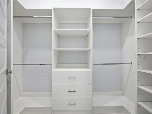 a view of walk in closet with empty racks