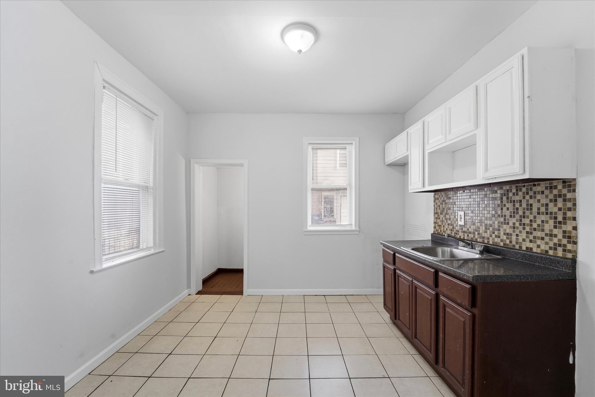 a kitchen with granite countertop a stove a sink and a window