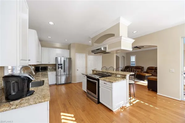 a kitchen with granite countertop a stove top oven a sink a counter space and cabinets