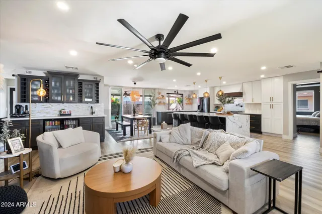 a living room with furniture a kitchen view and a chandelier