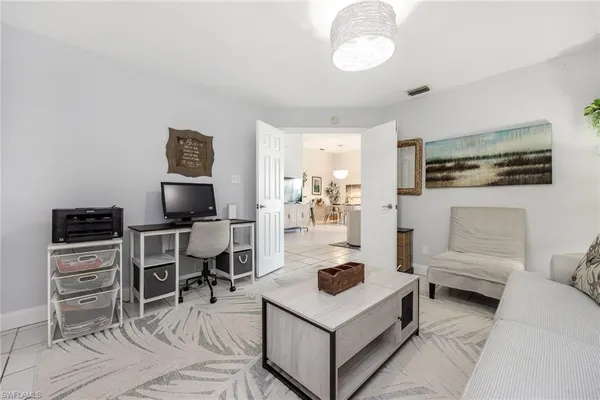a living room with furniture a flat screen tv and kitchen view