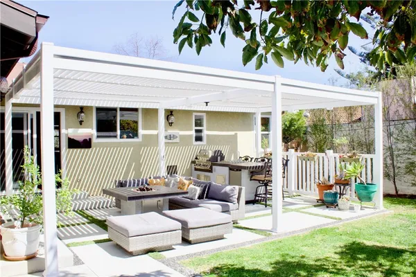 a view of a patio with couches table and chairs and potted plants
