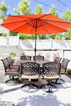 a roof deck with table and chairs under an umbrella