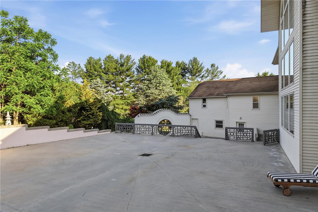 6271 Batman Road Zionsville, PA 18092 - Photo 92 of 100 A spacious concrete deck provides an ample outdoor living area, embraced by lush surrounding trees.