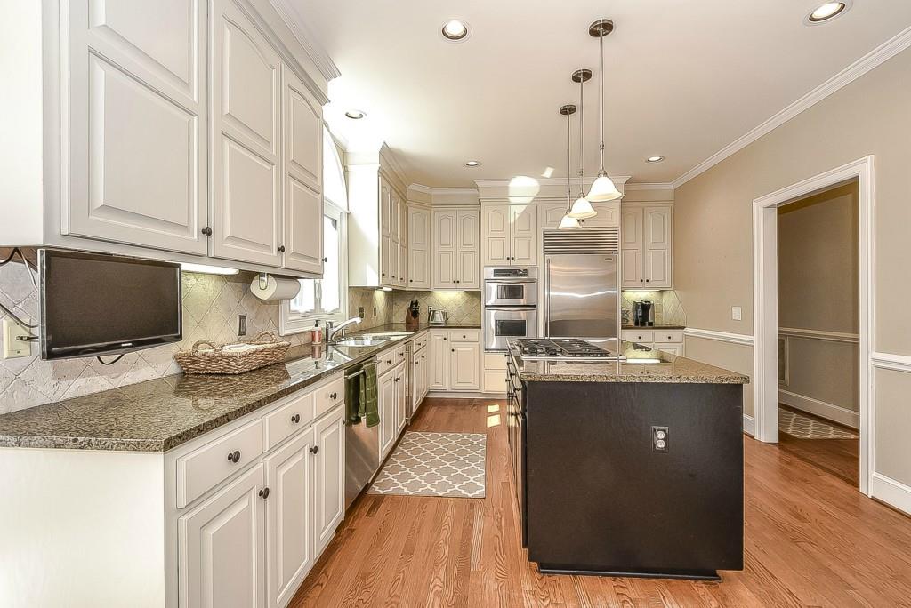3631 Plantation Road, Unit 15 Charlotte, NC 28270 - Photo 6 of 23 a kitchen with kitchen island granite countertop a sink cabinets and stainless steel appliances