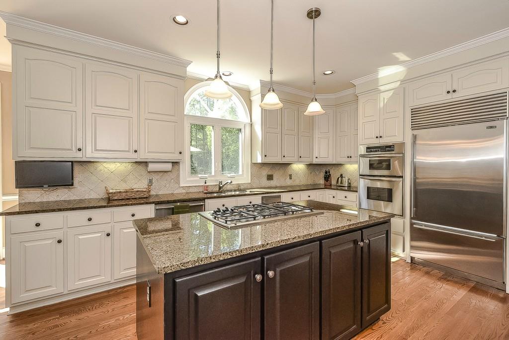 3631 Plantation Road, Unit 15 Charlotte, NC 28270 - Photo 7 of 23 a kitchen with stainless steel appliances granite countertop a sink a stove and a wooden floors