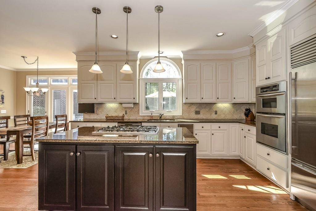 3631 Plantation Road, Unit 15 Charlotte, NC 28270 - Photo 8 of 23 a kitchen with kitchen island granite countertop stainless steel appliances a stove sink and cabinets