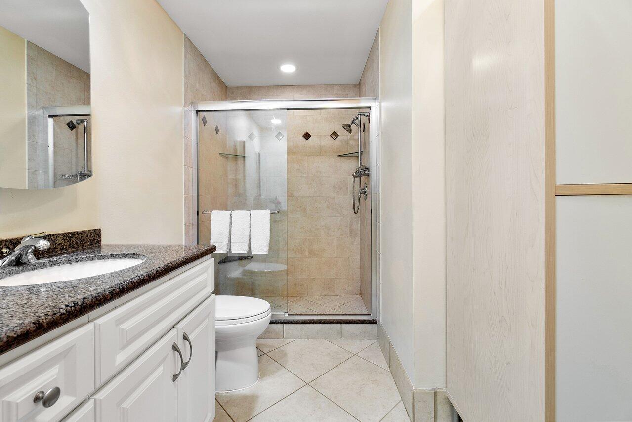 17266 Boca Club Boulevard, Unit 1603 Boca Raton, FL 33487 - Photo 24 of 42 a bathroom with a granite countertop sink a toilet a mirror and shower