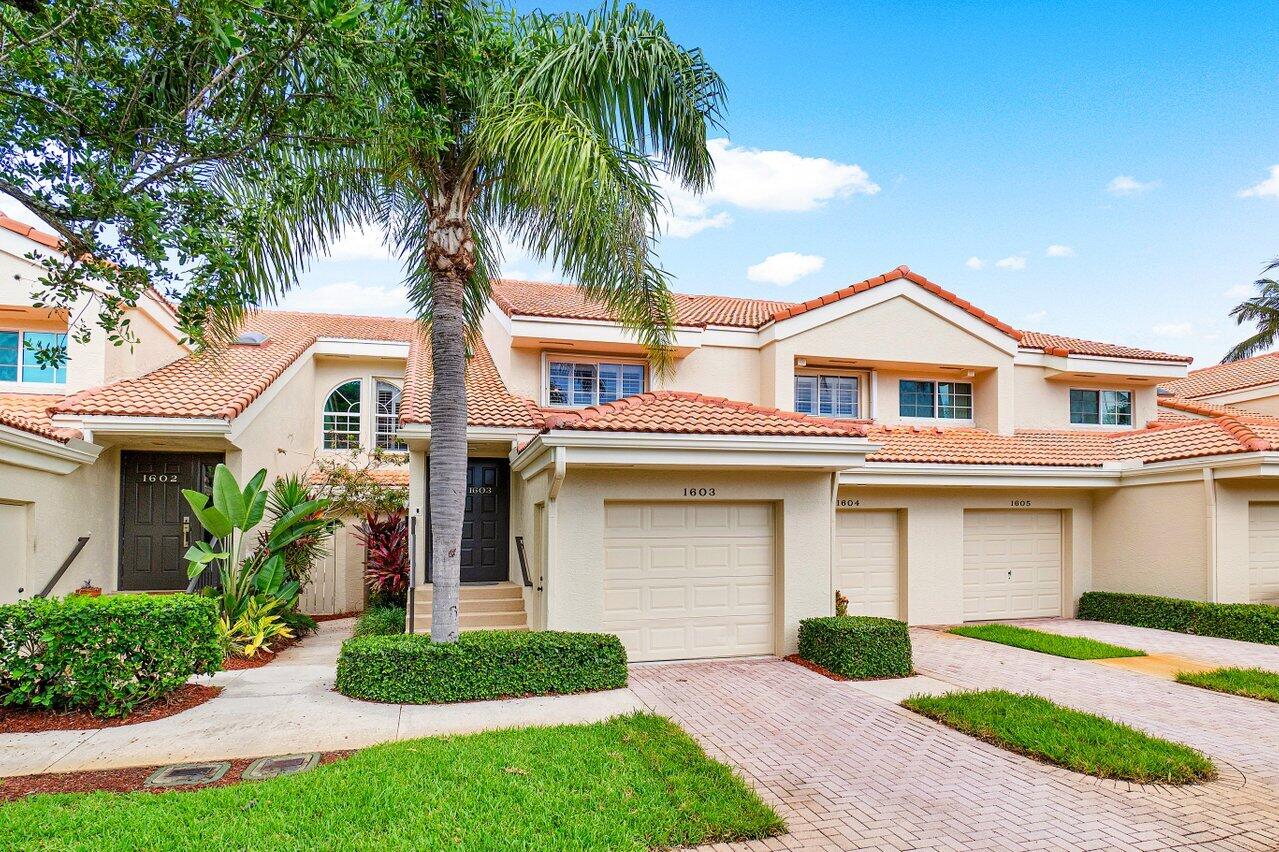 17266 Boca Club Boulevard, Unit 1603 Boca Raton, FL 33487 - Photo 4 of 42 a front view of a house with a garden and palm trees
