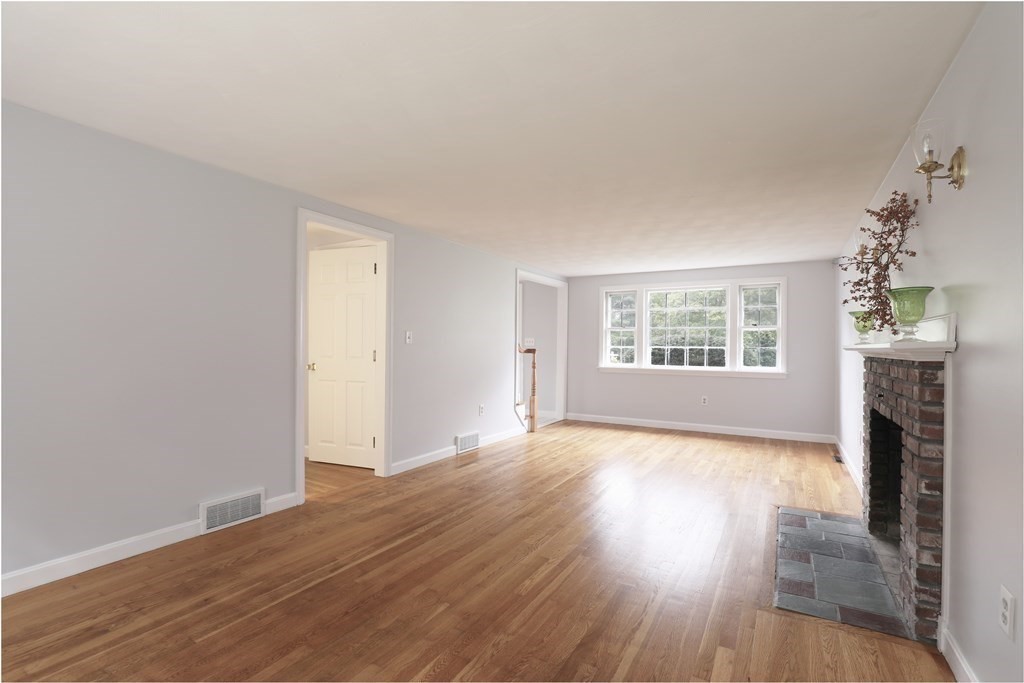 36 Parting Rock Road Duxbury, MA 02332 - Photo 7 of 29 an empty room with wooden floor fireplace and windows