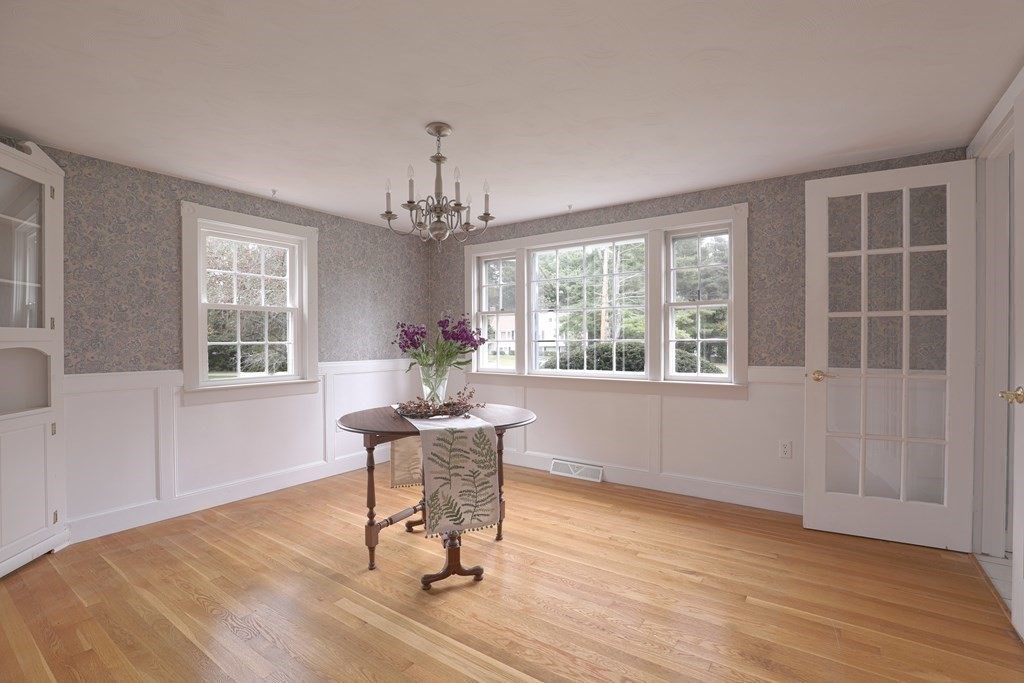 36 Parting Rock Road Duxbury, MA 02332 - Photo 10 of 29 a dining room with wooden floor a chandelier a wooden table and chairs