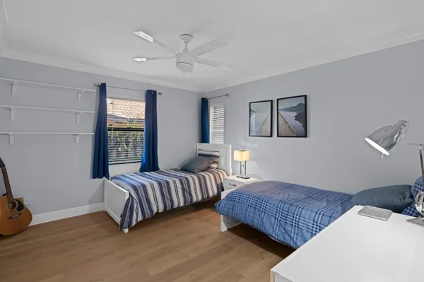 a bedroom with two beds and painting on the wall