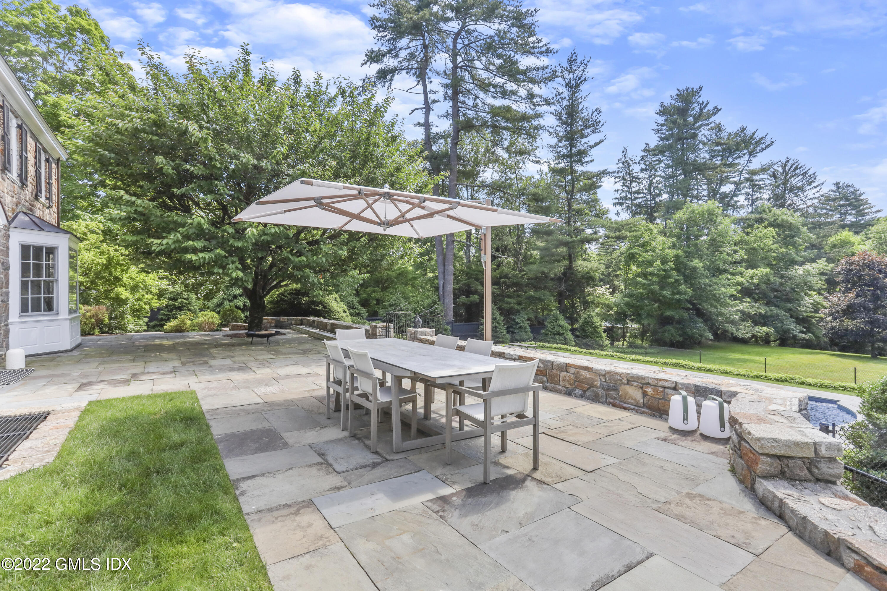 188 Stanwich Road Greenwich, CT 06830 - Photo 11 of 15 a view of a patio with a table and chairs under an umbrella