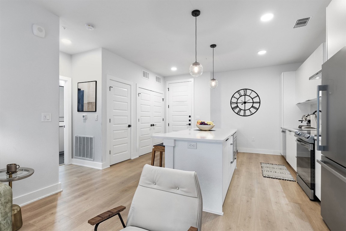 2500 Longview Street, Unit 418 Austin, TX 78705 - Photo 4 of 40 a large kitchen with cabinets a sink a window and stainless steel appliances