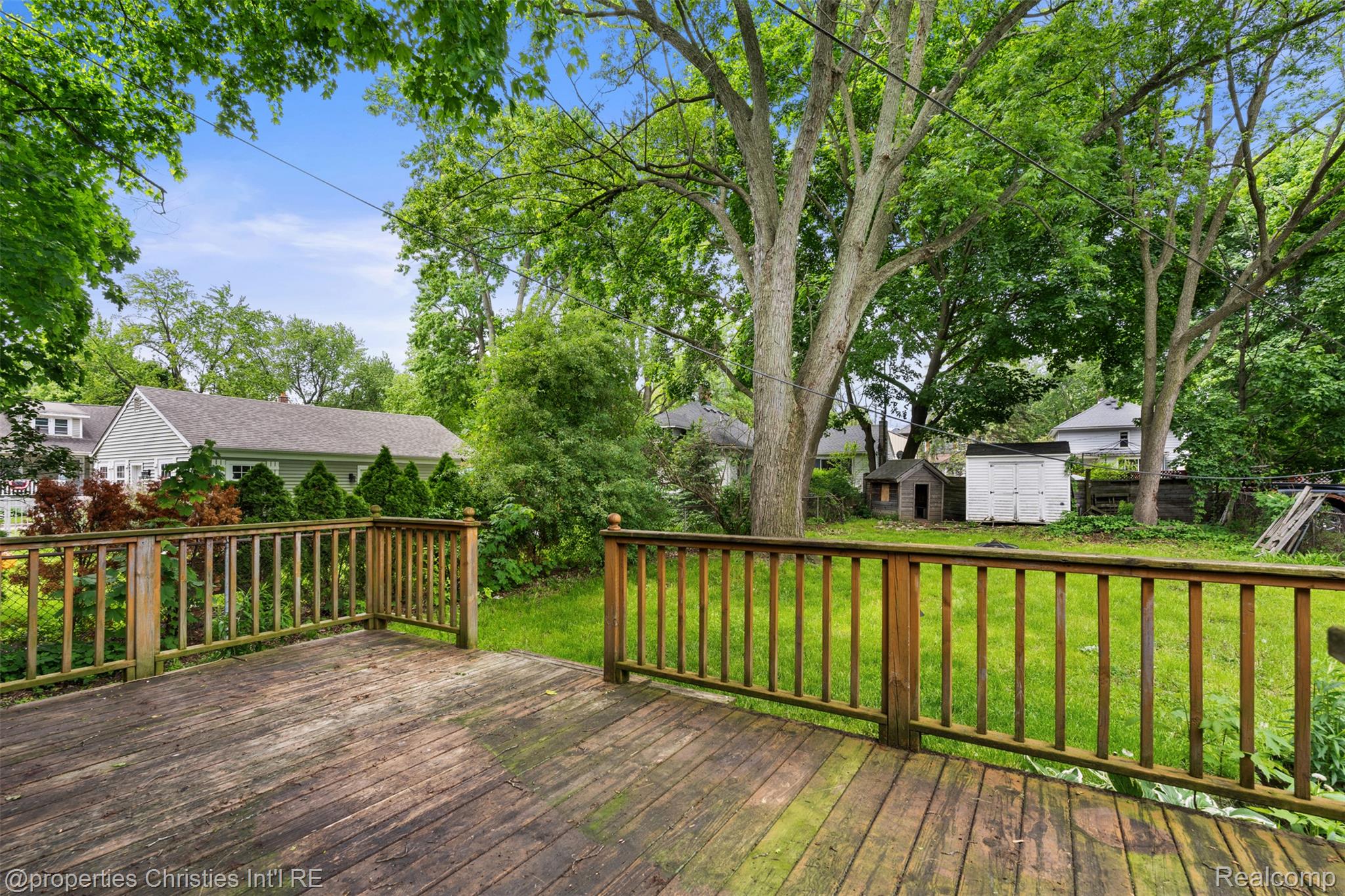 158 South Rawles Street Romeo, MI 48065 - Photo 37 of 53 Wood deck with railing overlooking a spacious backyard with mature trees and a manicured lawn