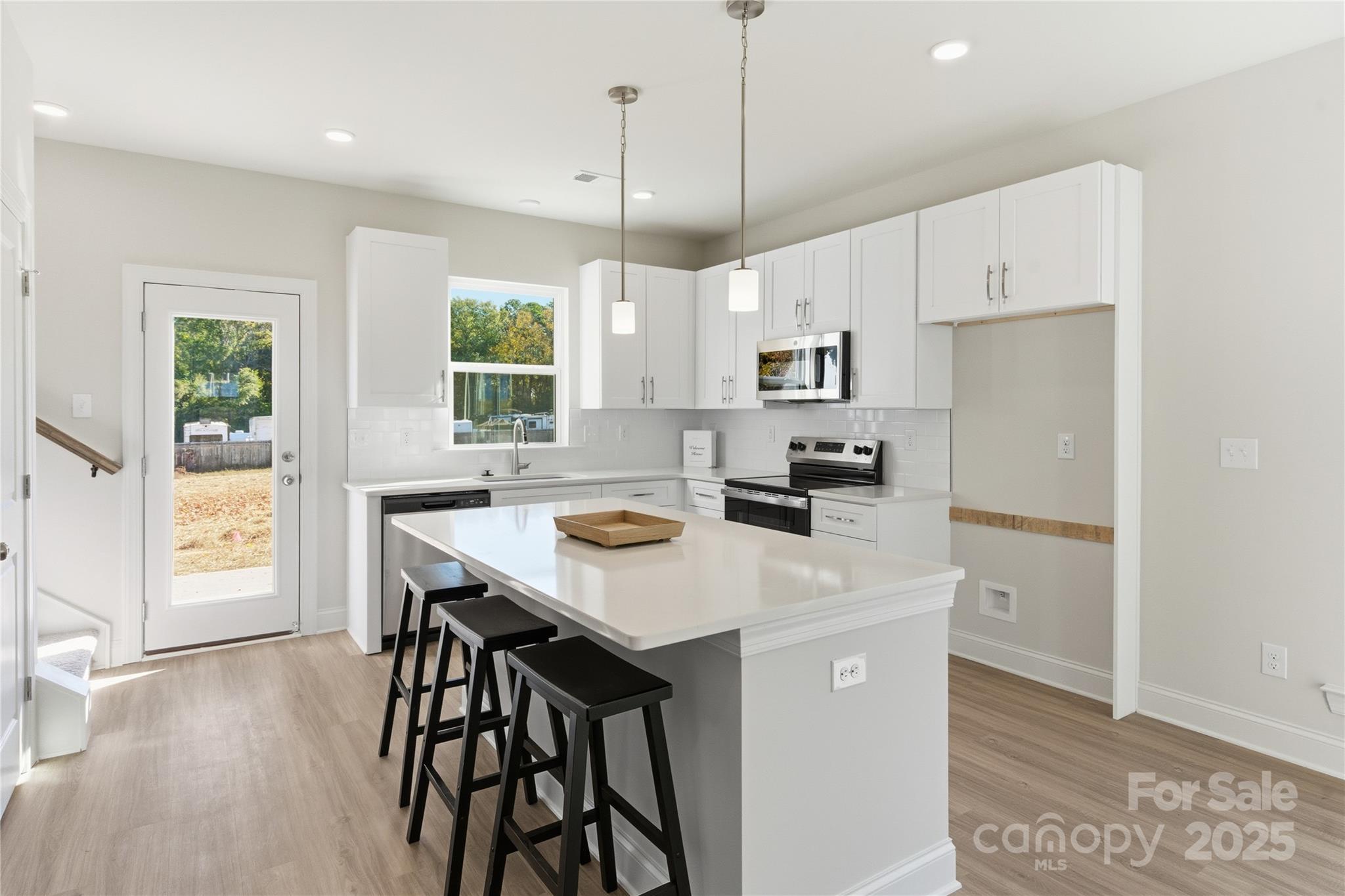 222 1st Street South Fort Mill, SC 29708 - Photo 5 of 23 a kitchen with stainless steel appliances a table chairs refrigerator and window