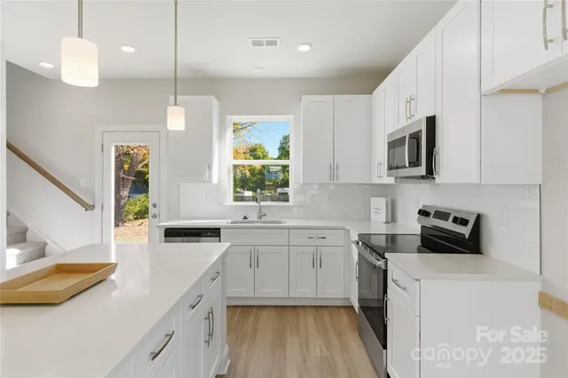 a kitchen with a sink a counter top space stainless steel appliances and cabinets