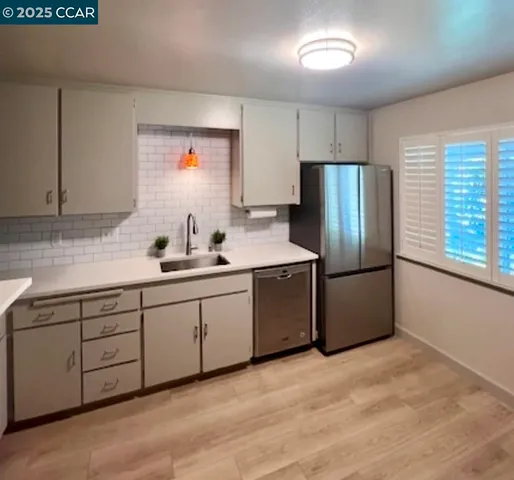a kitchen with stainless steel appliances a refrigerator sink and cabinets