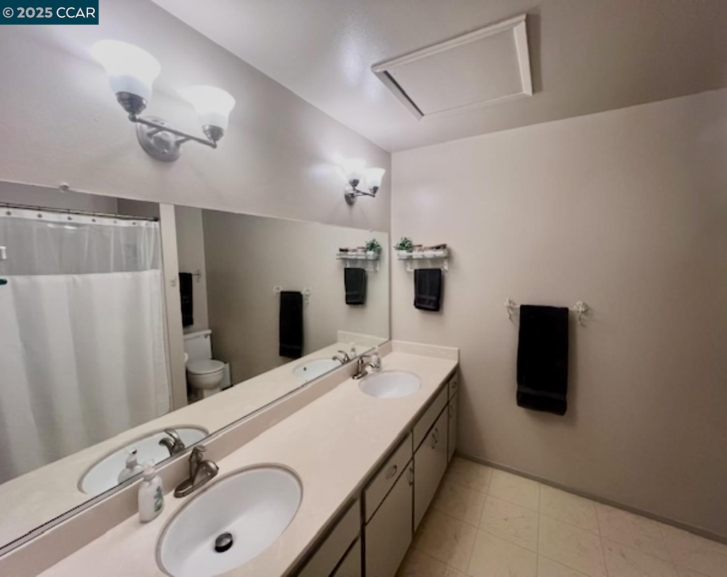 2129 Ascot Drive, Unit 15 Moraga, CA 94556 - Photo 7 of 9 a bathroom with a double vanity sink and mirror