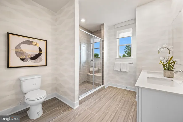 a bathroom with a toilet a sink and glass door