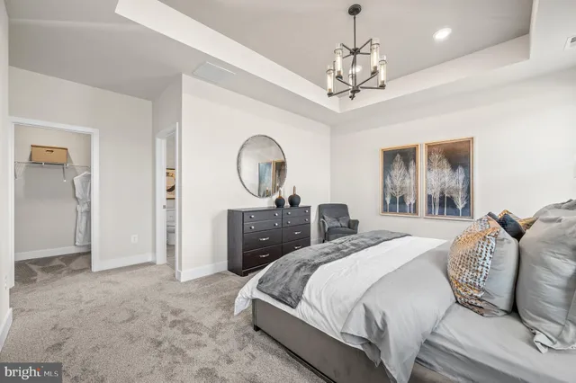 a bedroom with a large bed and a chandelier