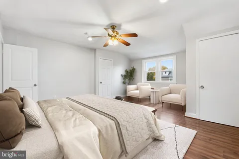 a bedroom with a white bed and ceiling fan
