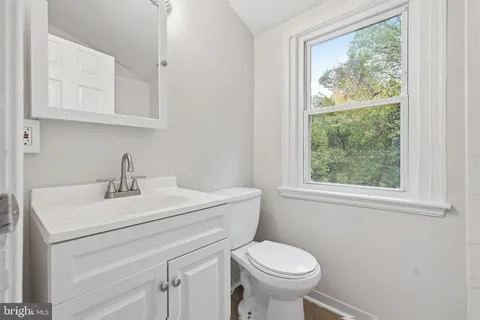 a bathroom with a sink a toilet and a window