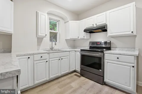 a kitchen with granite countertop white cabinets and appliances