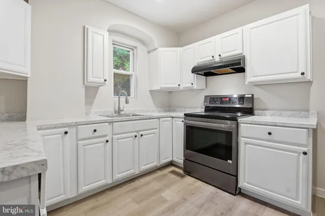 a kitchen with granite countertop white cabinets and appliances