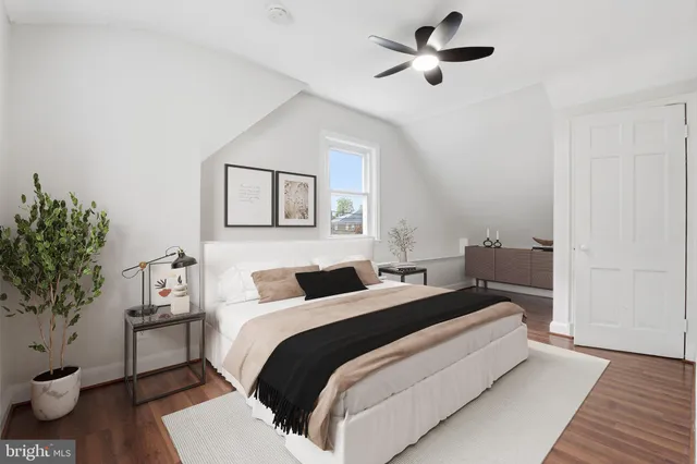 a bedroom with a bed and a potted plant