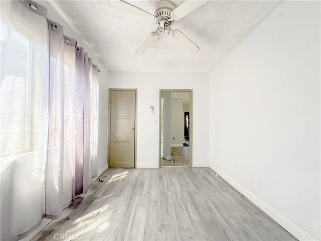 a view of a hallway with wooden floor and a chandelier fan