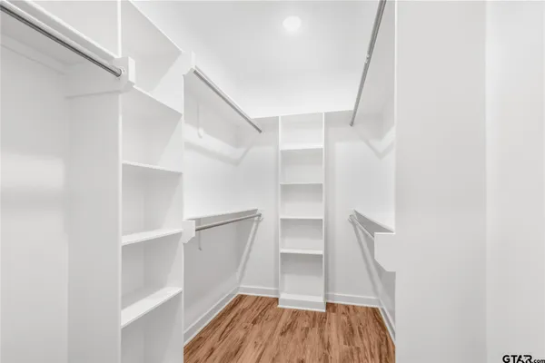 a view of walk in closet with wooden floor