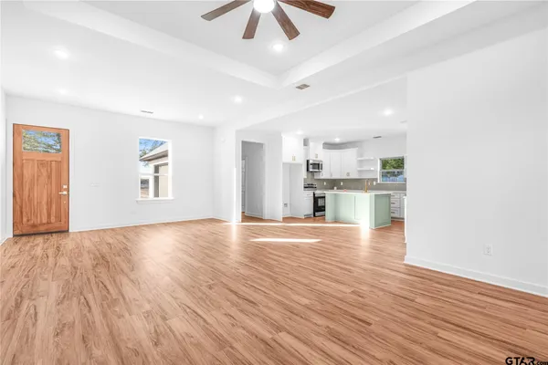 a view of empty room with wooden floor and window
