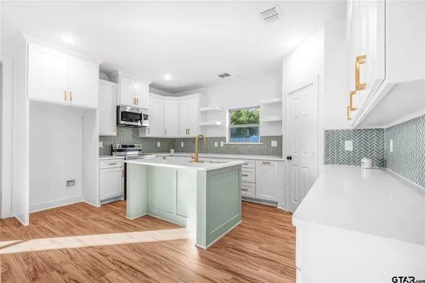 a kitchen with a sink a stove a refrigerator and cabinets