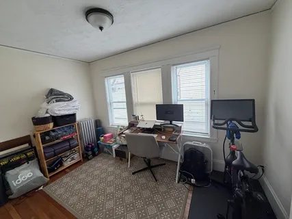 a view of a livingroom with workspace and a window