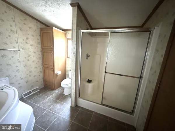 a bathroom with a granite countertop shower toilet and sink