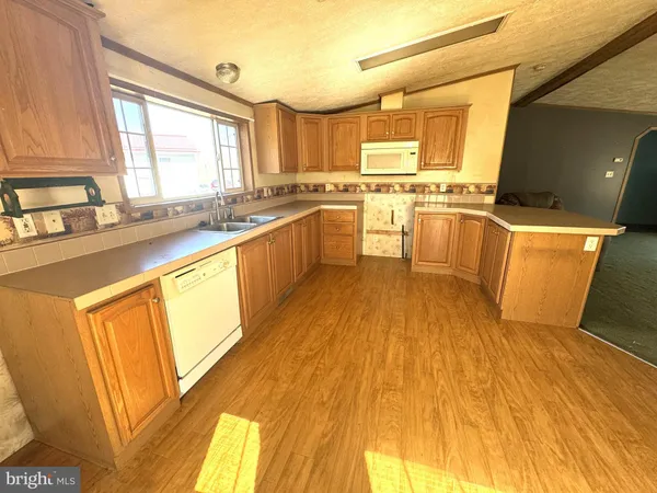 a large kitchen with wooden floors and white stainless steel appliances