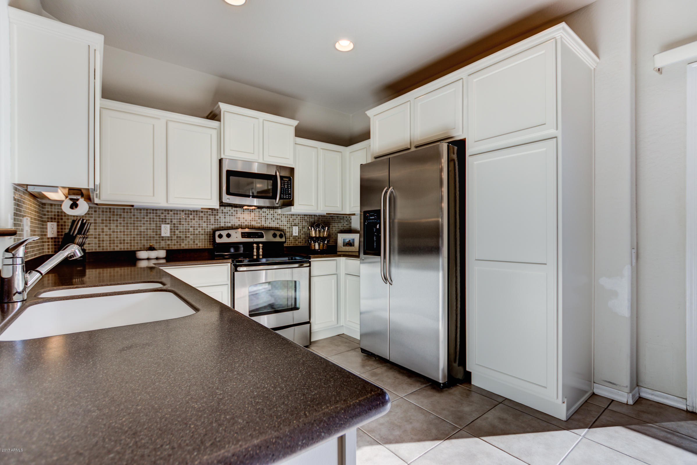 1935 West Davis Road Phoenix, AZ 85023 - Photo 13 of 30 a kitchen with granite countertop a refrigerator stove and microwave