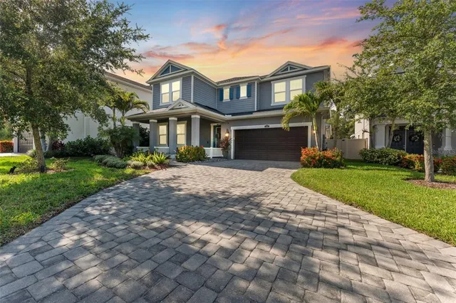 a front view of a house with a yard and trees