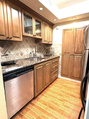 a kitchen with stainless steel appliances granite countertop a refrigerator sink and cabinets