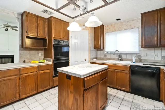 a kitchen with stainless steel appliances granite countertop a sink counter space cabinets and a window