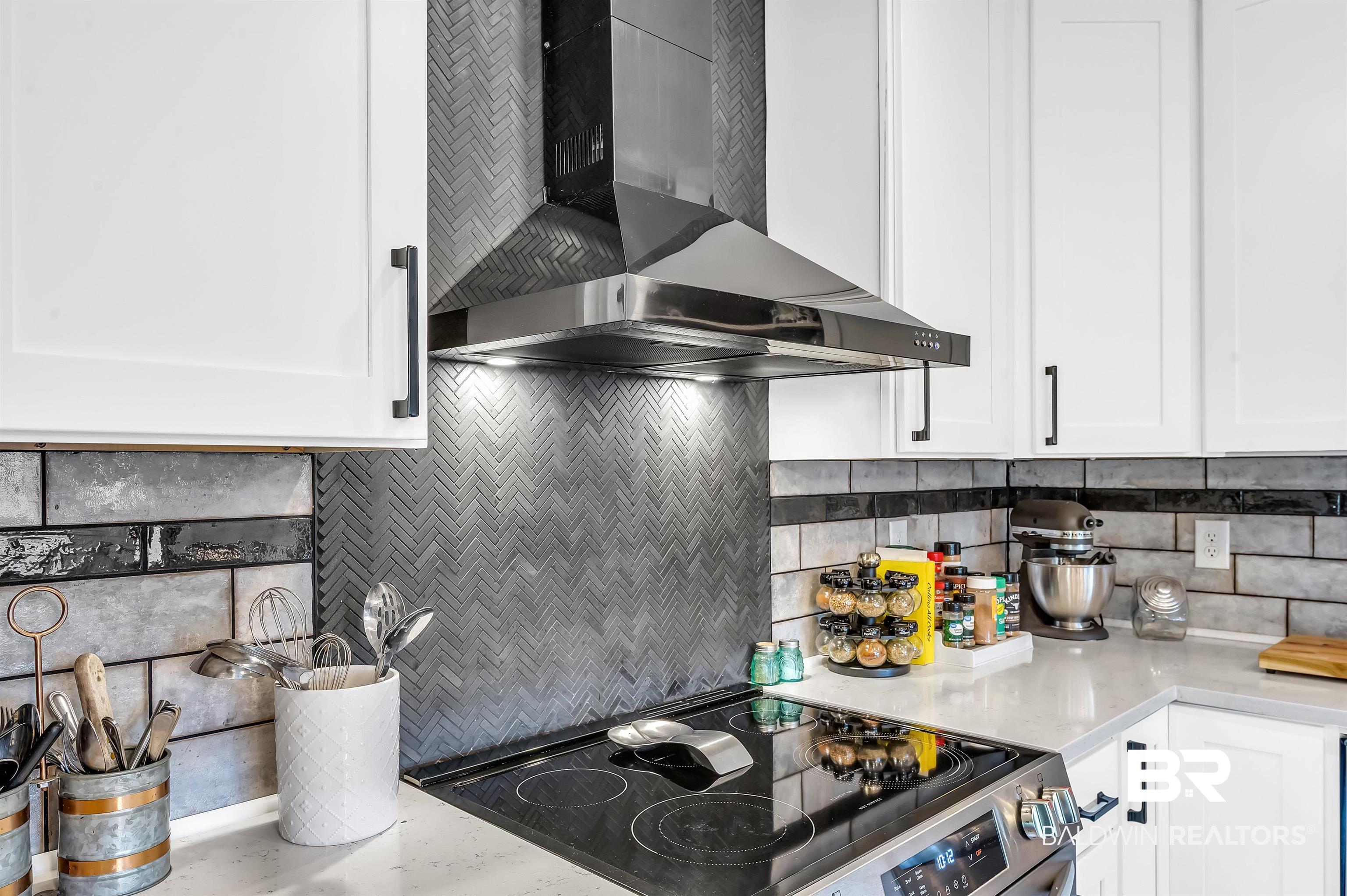 5215 Pine Road Orange Beach, AL 36561 - Photo 23 of 60 Kitchen featuring wall chimney range hood, stainless steel electric range oven, and white cabinets