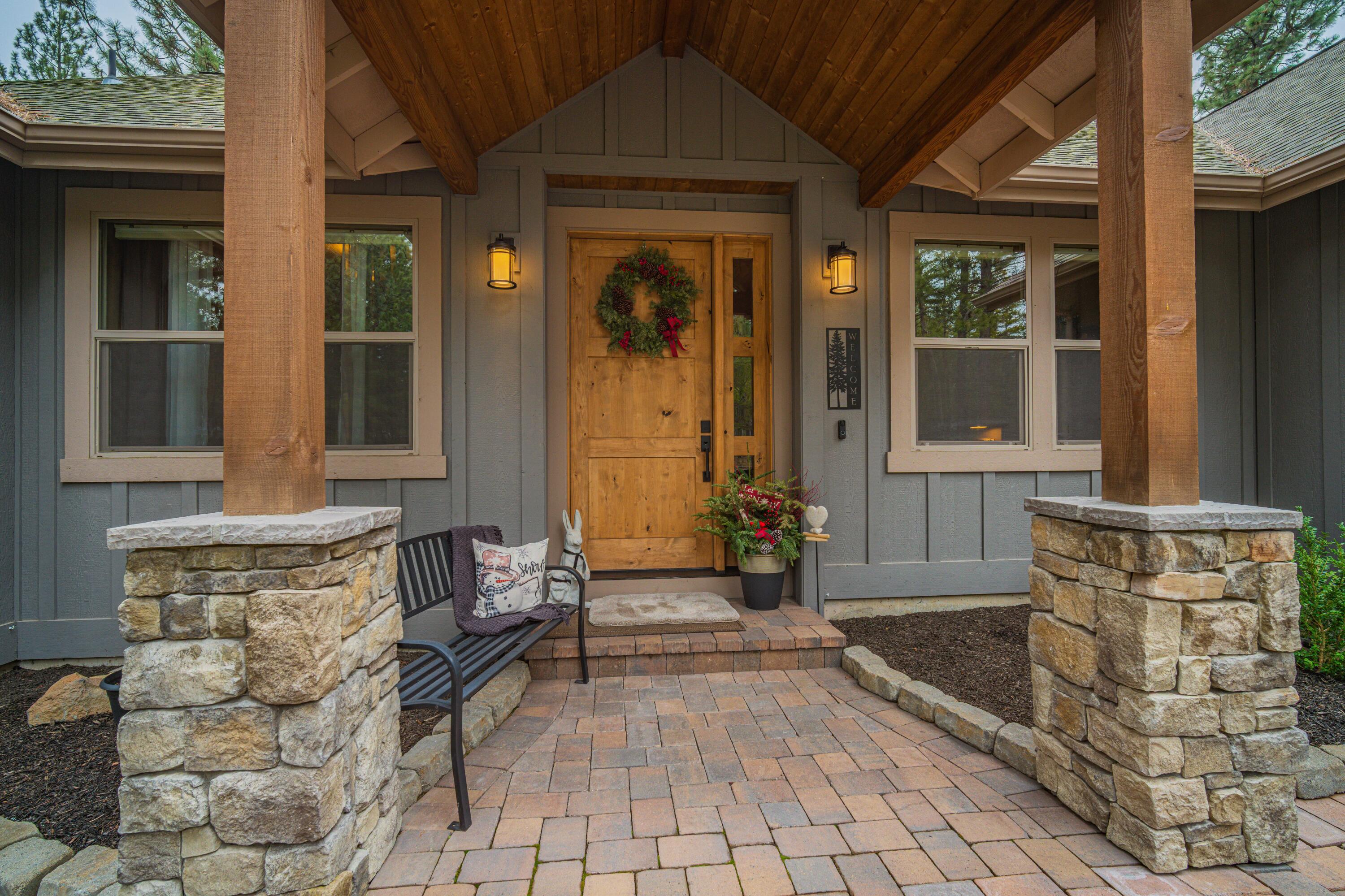 16927 Covina Road Bend, OR 97707 - Photo 4 of 54 Covered front entry with timber beams, stone columns, and a warm lodge-style presence that sets the tone for this exceptional home.