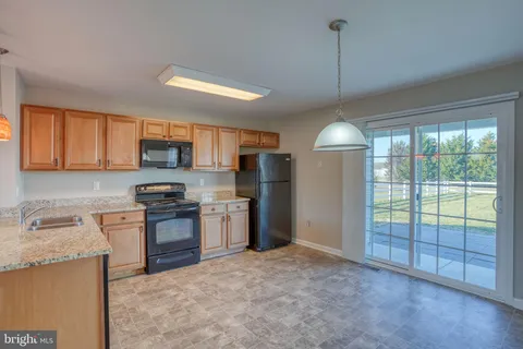 a kitchen with stainless steel appliances granite countertop a stove refrigerator sink and microwave