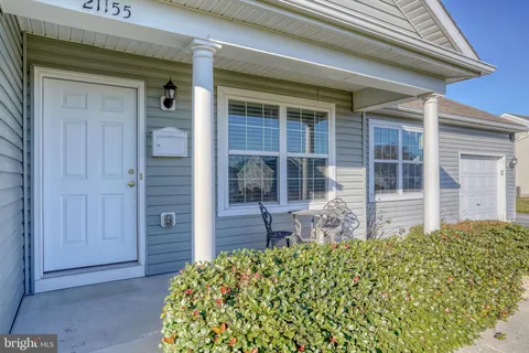 front view of a house with a large window and bench