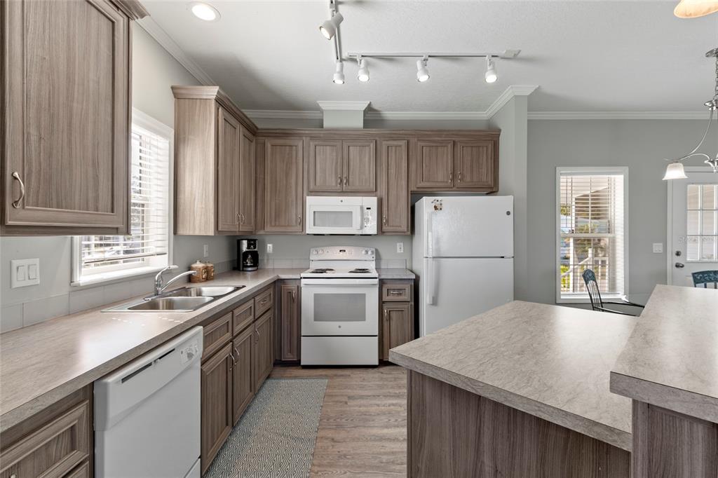 4104 11th Street East Ellenton, FL 34222 - Photo 2 of 20 a kitchen with a sink a stove a refrigerator and white cabinets