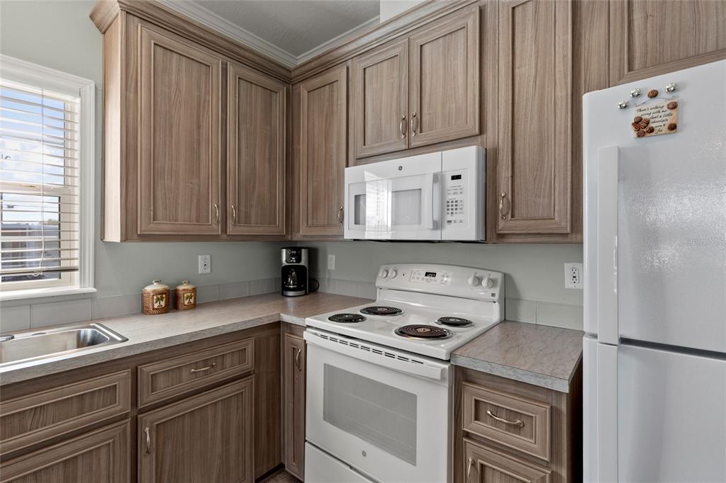 4104 11th Street East Ellenton, FL 34222 - Photo 3 of 20 a kitchen with stainless steel appliances granite countertop a refrigerator sink and cabinets