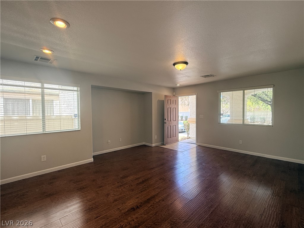 11953 Fairfax Ridge Street Las Vegas, NV 89183 - Photo 3 of 32 Rich hardwood flooring extends throughout this well-lit living space, creating a warm and inviting atmosphere.
