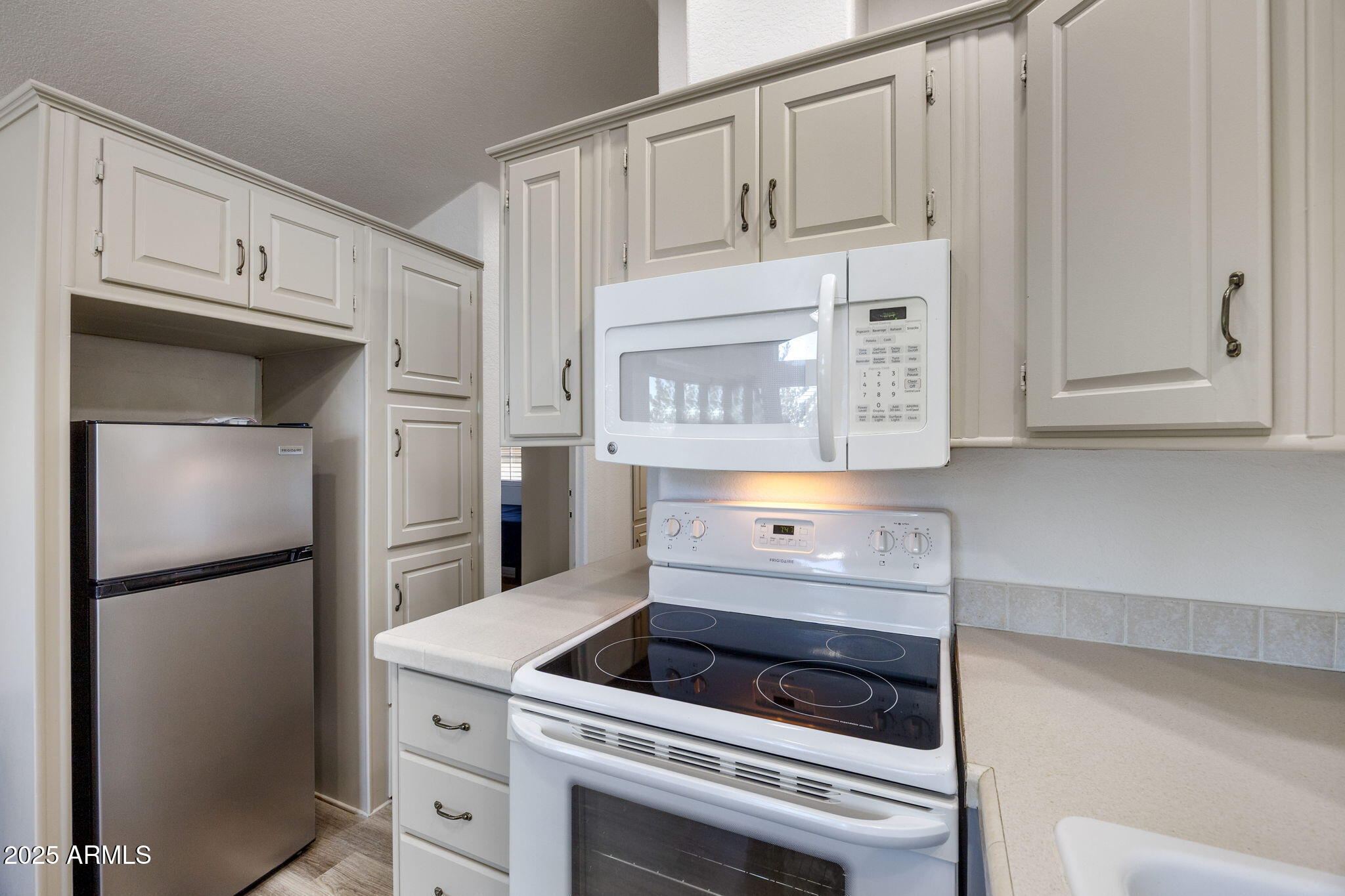 2209 Old Crooks Trail Overgaard, AZ 85933 - Photo 11 of 38 a kitchen with white cabinets and a refrigerator